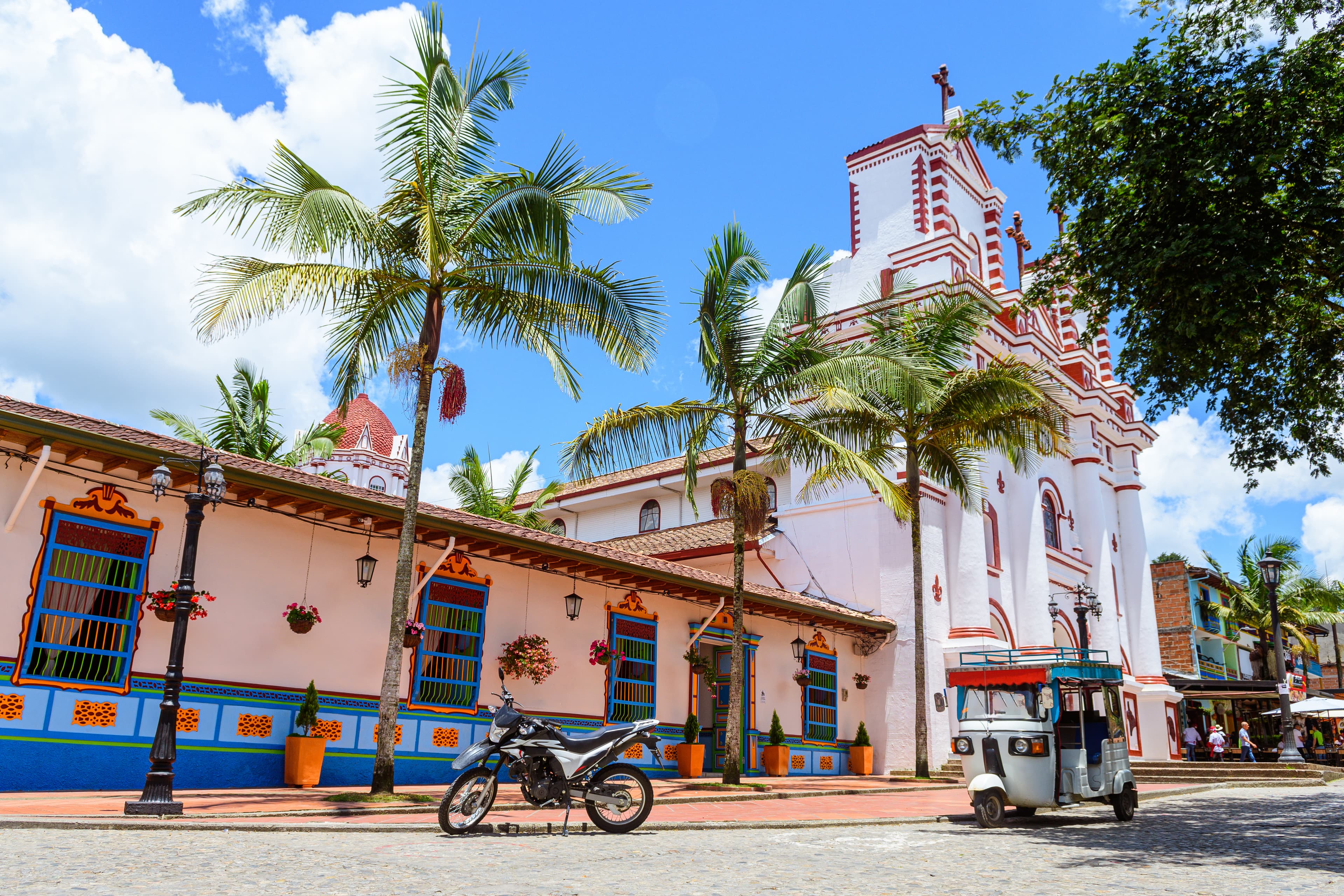 Colourful colonial town square with church and palms