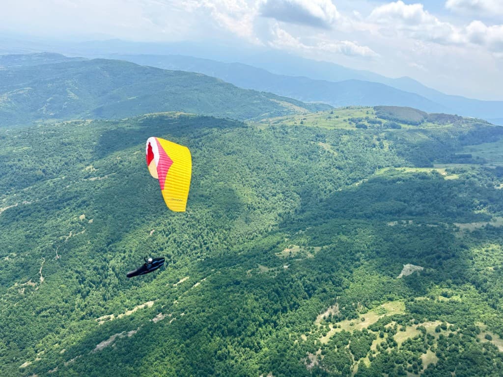 Pilot soaring over endless rolling hills