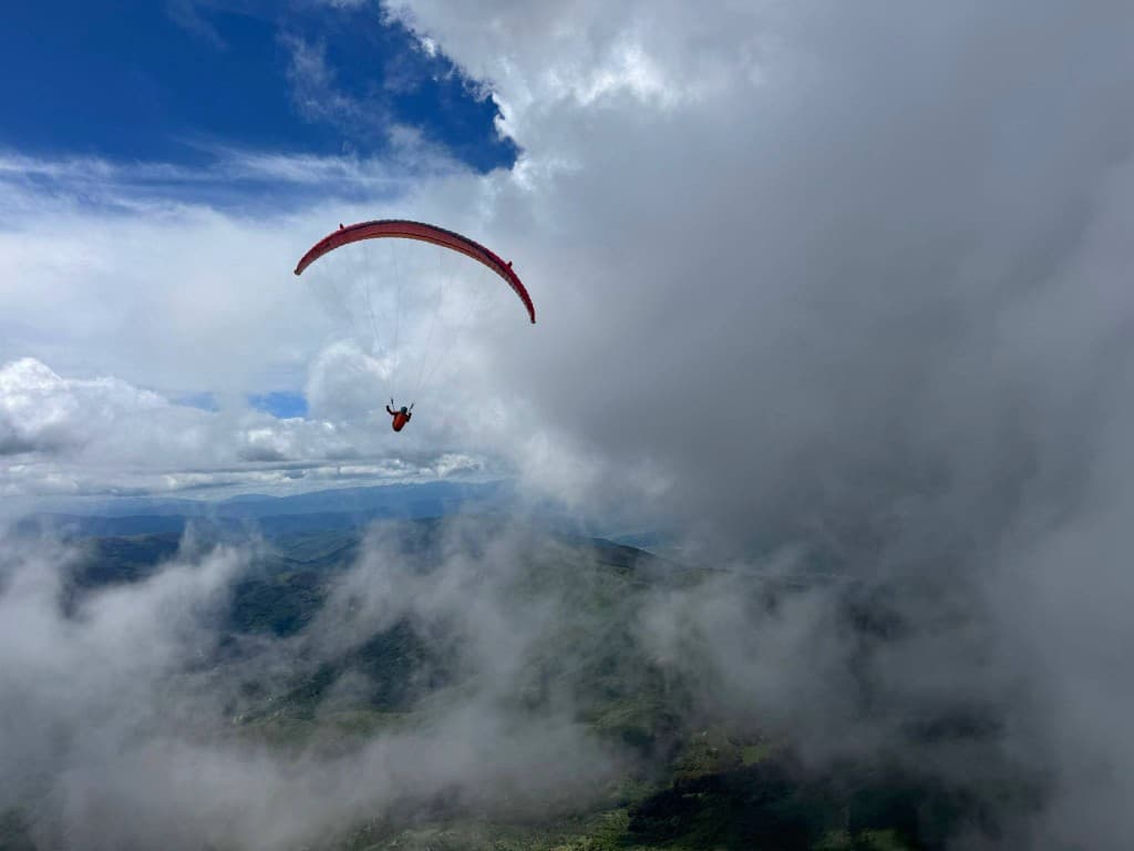 Paraglider drifting past a dramatic cloudscape