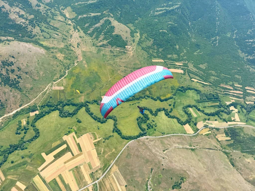 Several paragliders sharing a thermal over the ridges