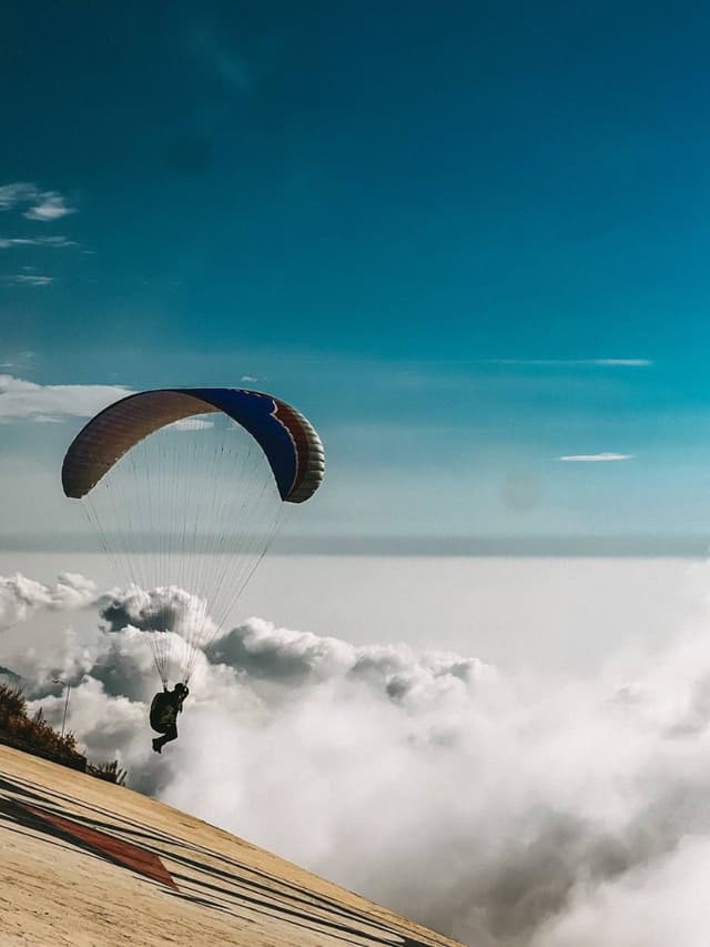 Paraglider above a sea of clouds