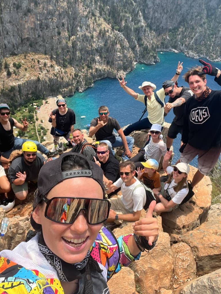 The whole group celebrating above a turquoise bay